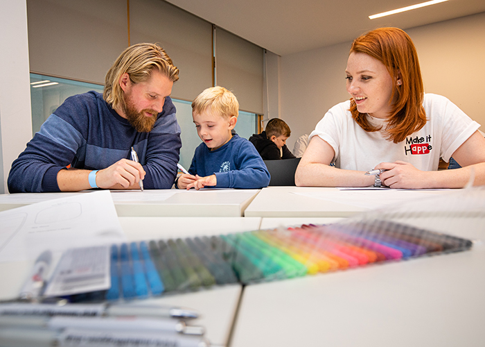 Family working around the table with colouring in pens